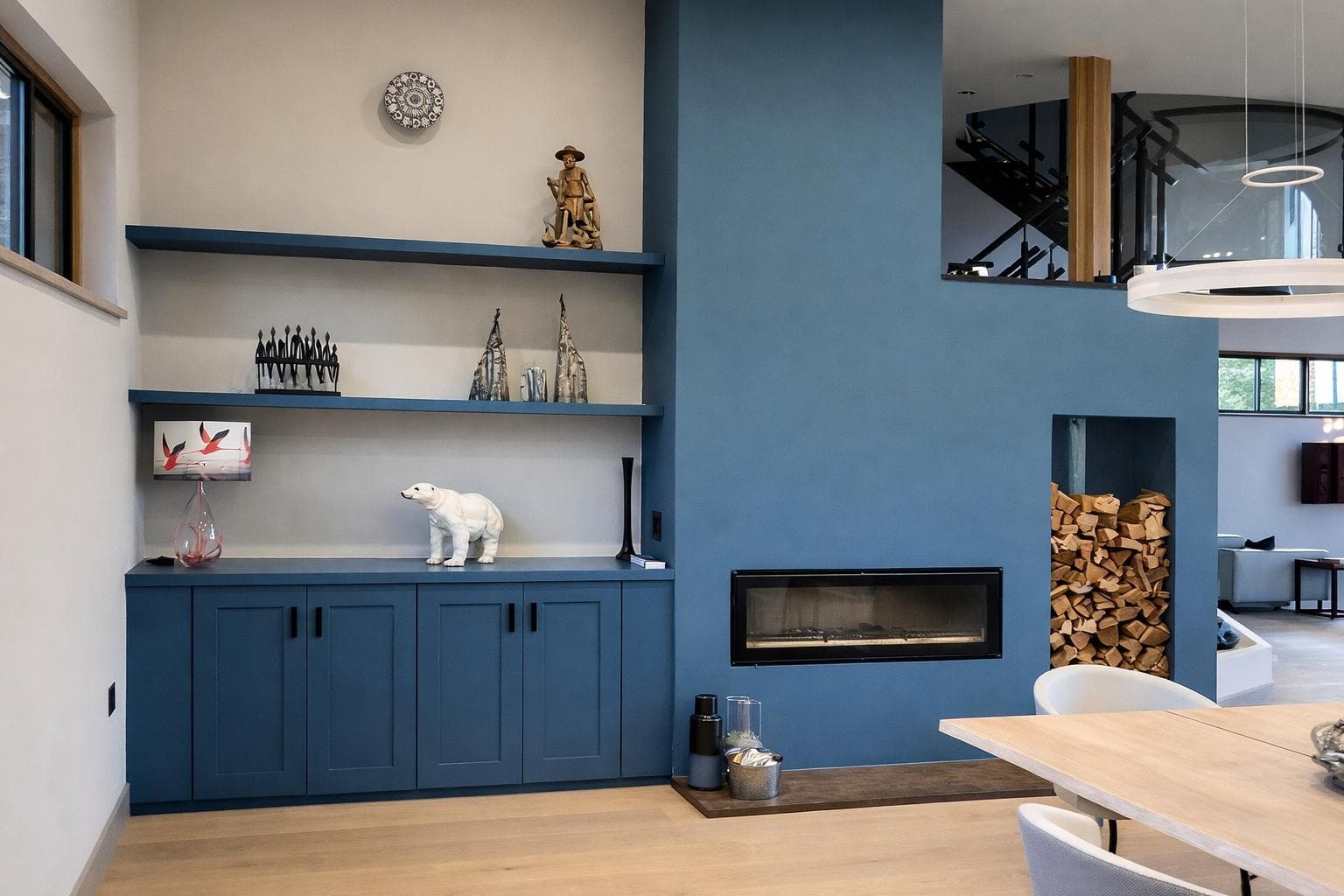 Blue painted alcove units with fireplace surround and log store