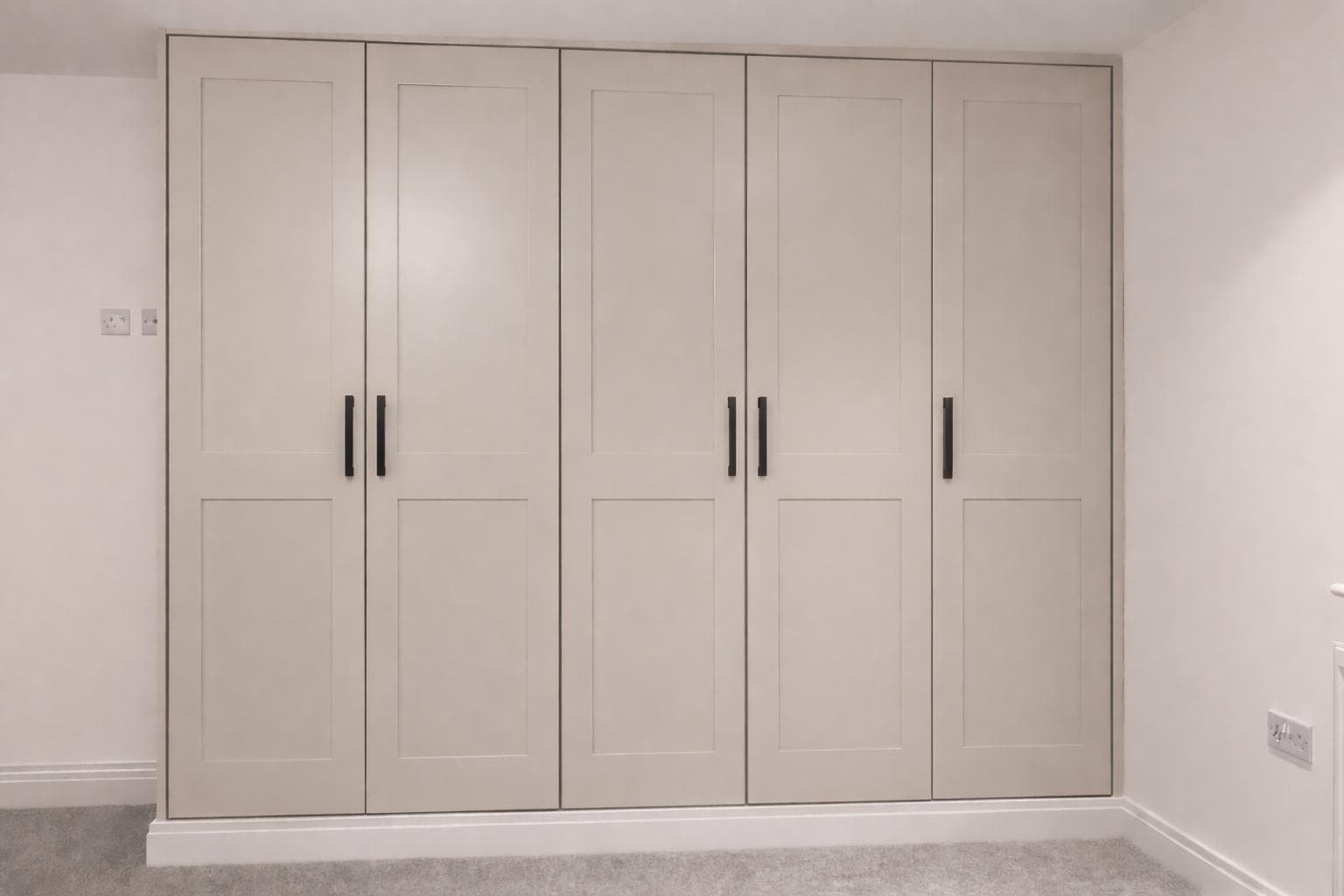 Cream shaker-style fitted wardrobes with decorative mouldings