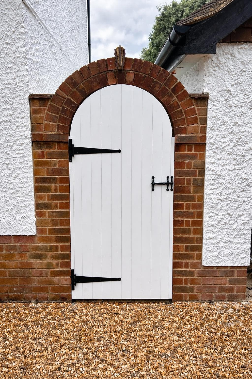 White painted arched garden gate with decorative lattice design